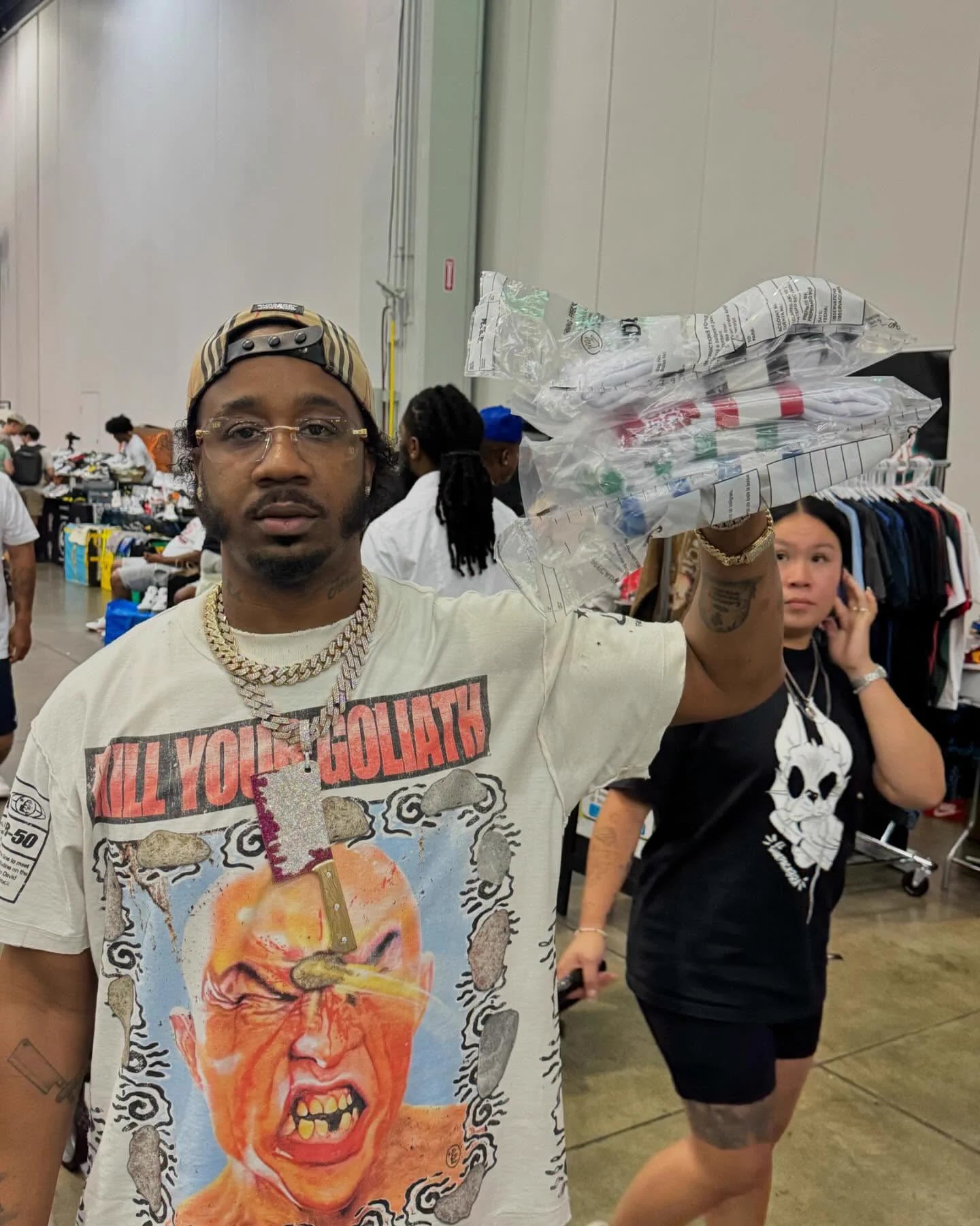 Benny holding sealed Argent Money Socks packs at a streetwear event