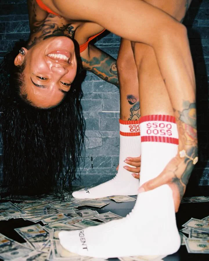 Red Money Socks photographed over scattered currency